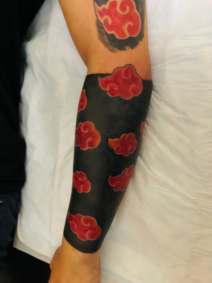 a person with a black and red tattoo on their arm