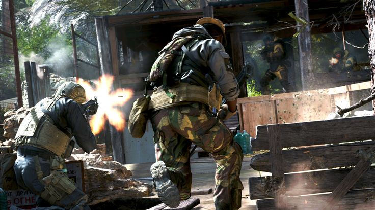 two men in camouflage gear are playing with fireballs while another man looks on from the other side