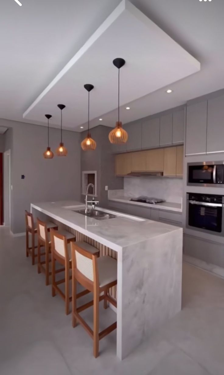 a modern kitchen with an island and bar stools