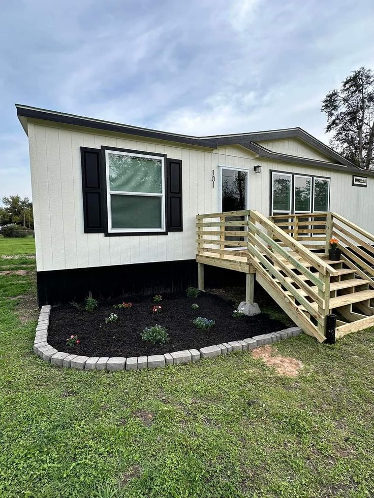 a mobile home with steps leading to the front door