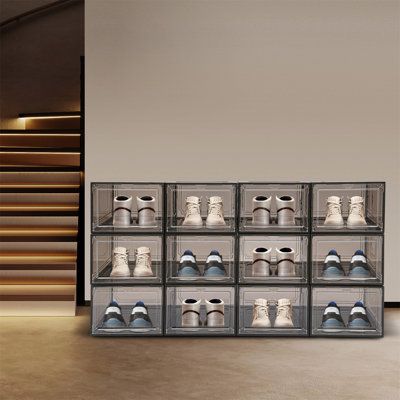 a display case filled with pairs of shoes in front of stairs and staircase railings