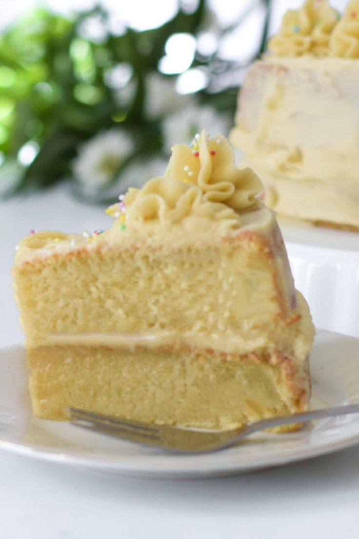 a piece of cake on a white plate with a fork in front of the slice