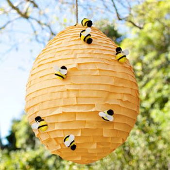 a beehive hanging from a tree with bees on it