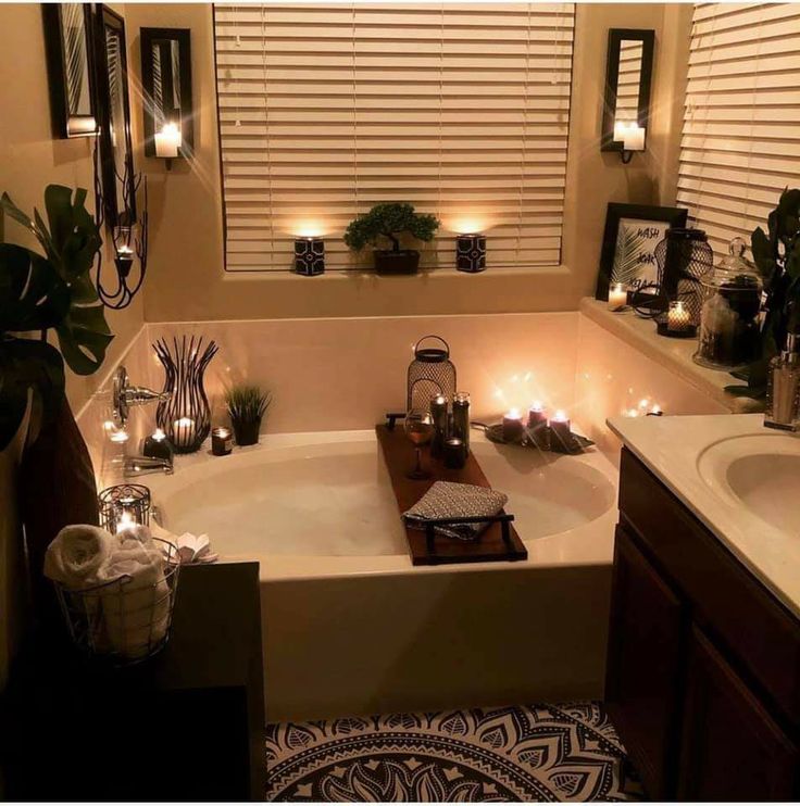 a bath tub with candles in it next to a window