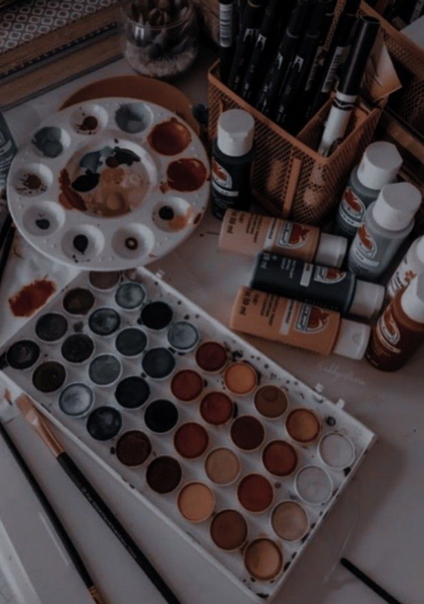 an artist's palette and other art supplies sit on a table in front of the camera