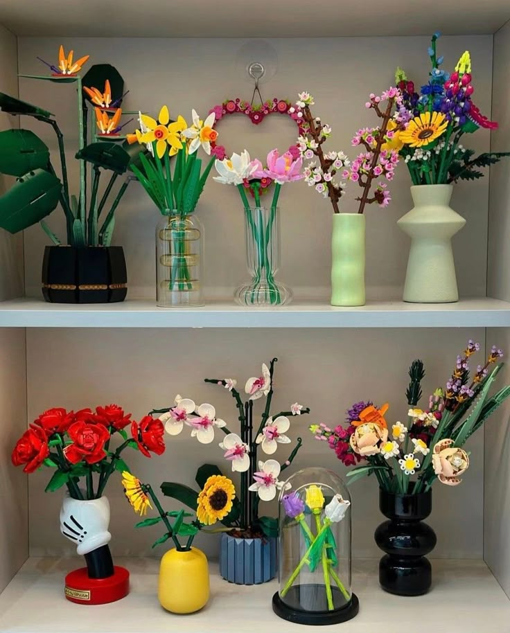 several vases with flowers are sitting on shelves