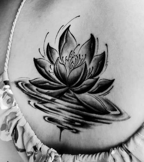 a woman's stomach with a lotus tattoo on her belly and water lilies