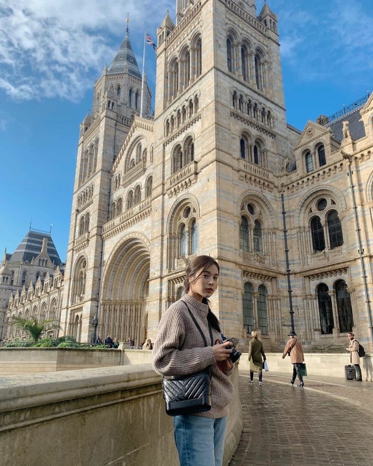 a woman standing in front of a large building