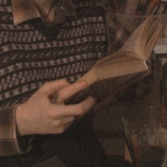 a man reading a book while sitting at a table