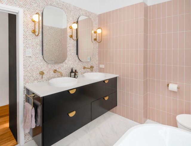 a bathroom with two sinks, mirror and bathtub next to each other in it