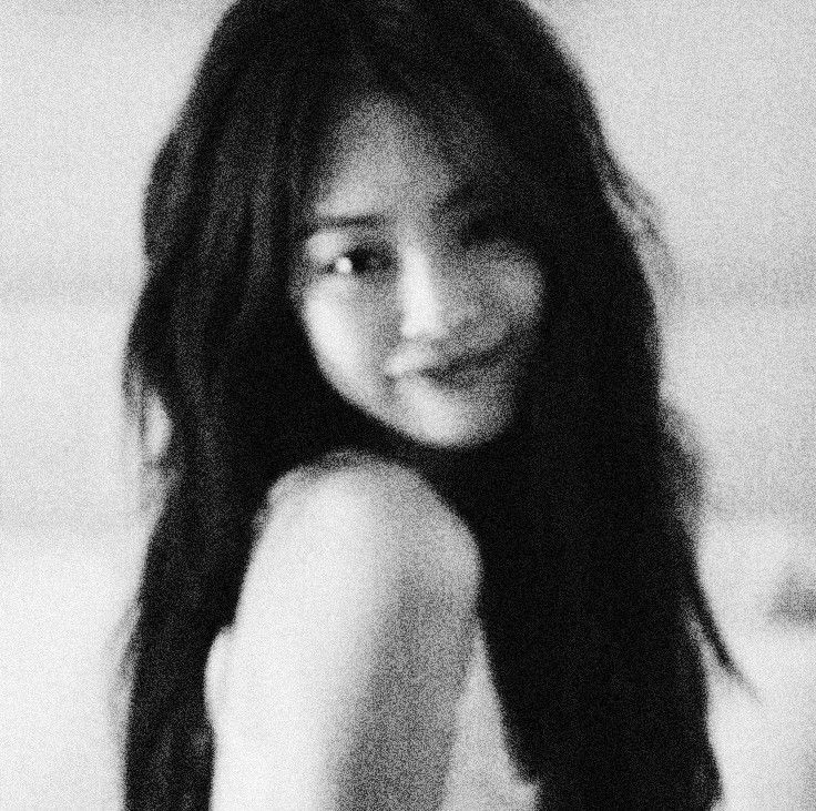 a black and white photo of a woman with long dark hair smiling at the camera