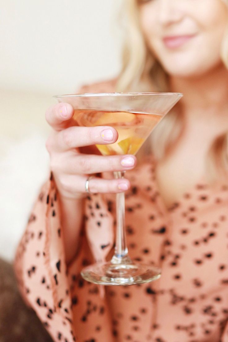 a woman holding a martini glass in her hand