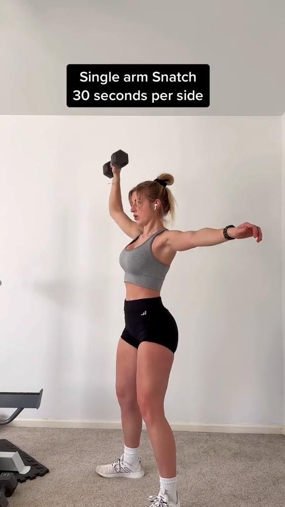 a woman holding two dumbbells while standing in front of a treadmill with the text, single arm snatch 30 seconds per side