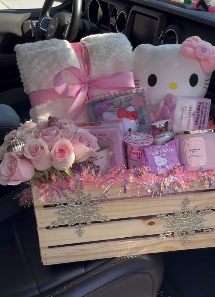 a hello kitty themed gift basket in the back seat of a car with pink roses