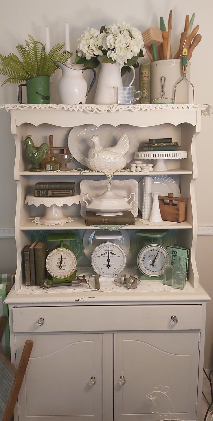 an old china cabinet with clocks and other items