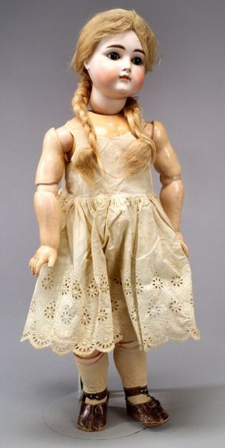 an old doll with blonde hair wearing a dress