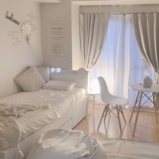 a bedroom with white furniture and curtains on the windowsill