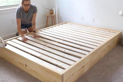 a man laying on top of a wooden bed frame