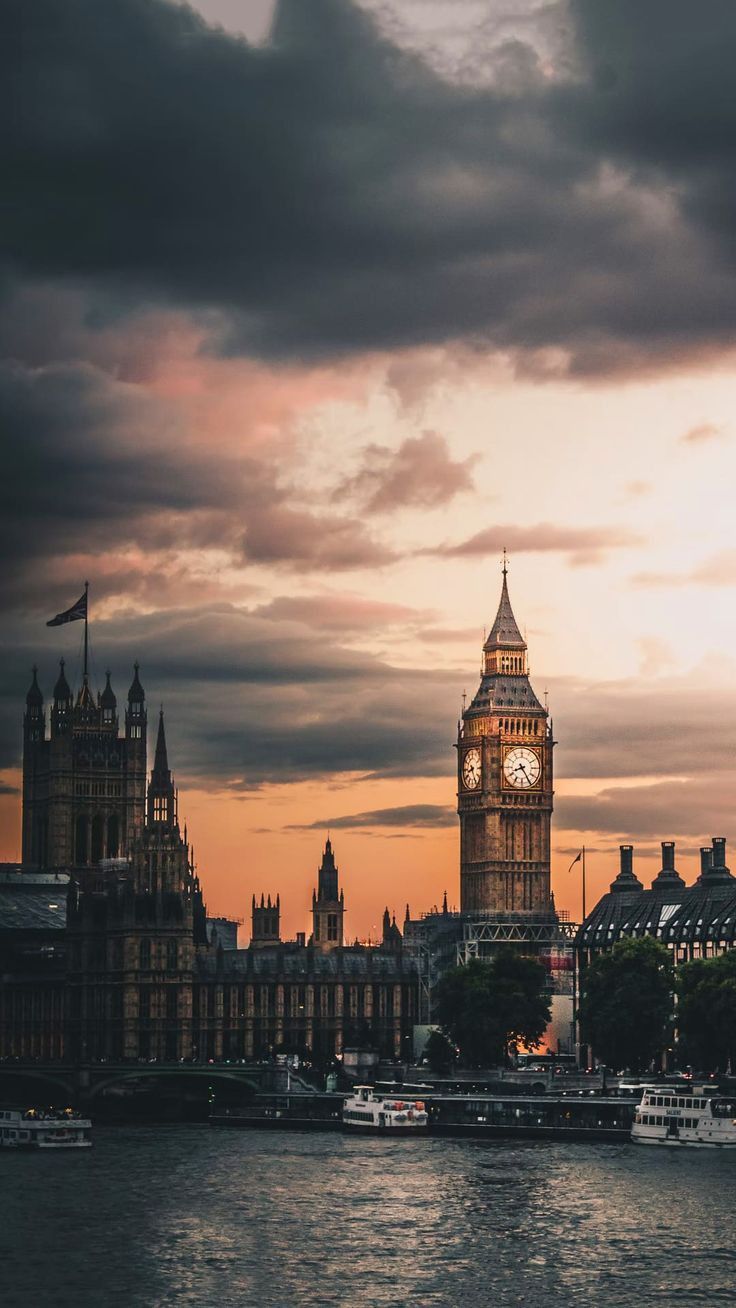 the big ben clock tower towering over the city of london, england at sunset or dawn