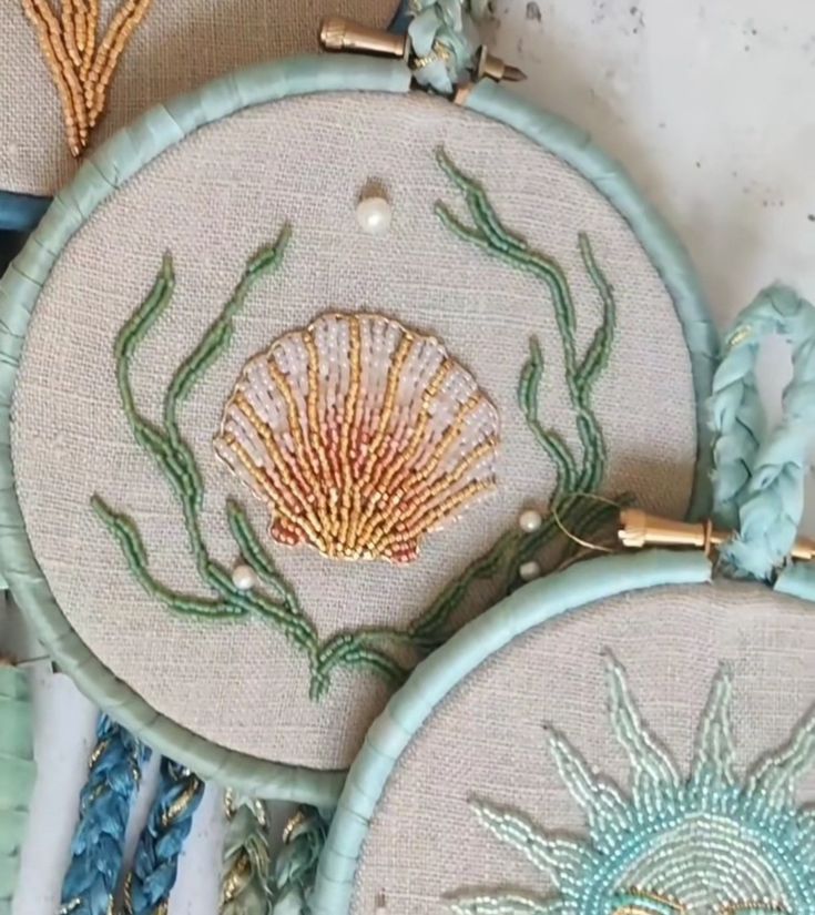 three embroidery hoops with sea shells on them