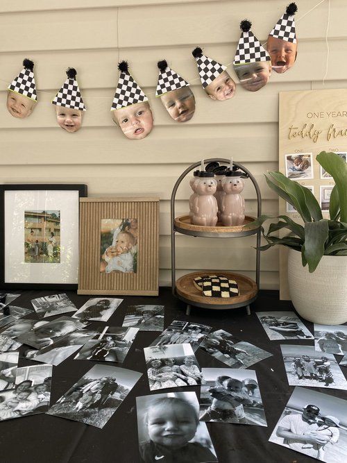 a table topped with pictures and photos next to a potted plant