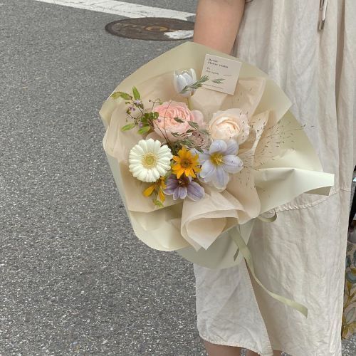 a woman holding a bouquet of flowers on the street