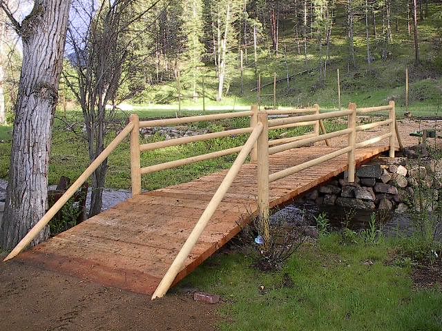 a wooden bridge over a stream in the woods