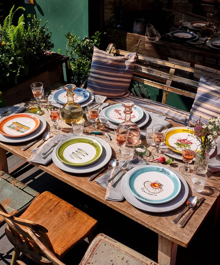 the table is set with plates and glasses