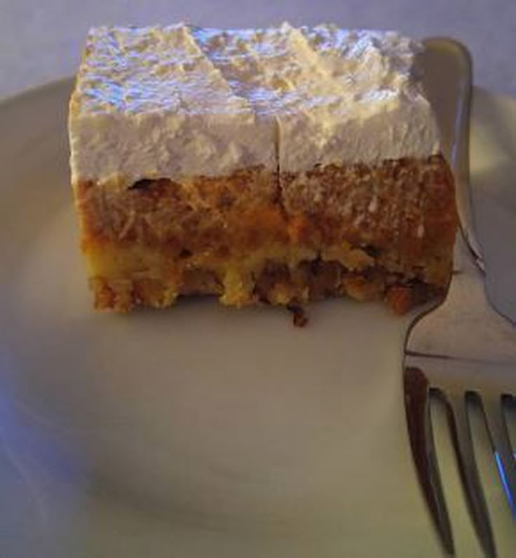 a piece of cake sitting on top of a white plate with a fork next to it