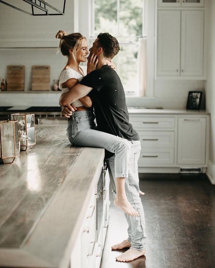 a man and woman are hugging in the kitchen