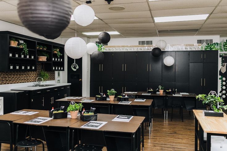 an empty classroom with desks, chairs and hanging plants on the wall above them