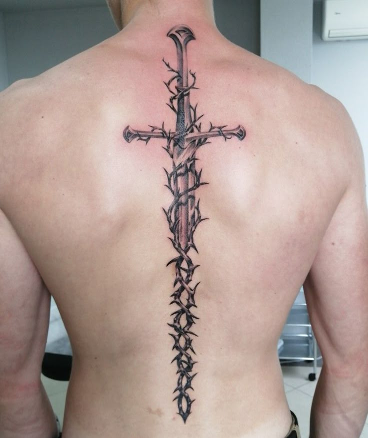 a man with a cross tattoo on his back