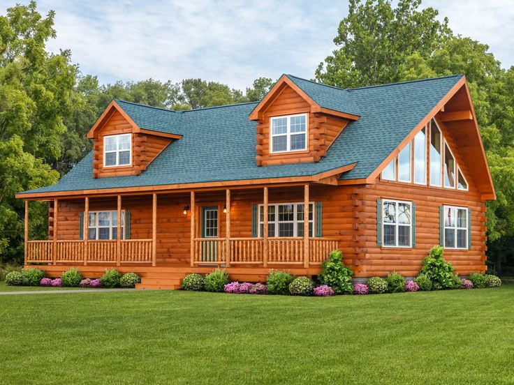 a large log cabin home with front porch and wrapper windows on the second floor