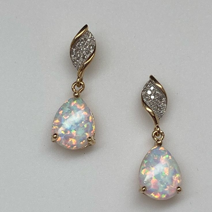 Set Securely At The Bottom Of The Earring Is A Pear Shape Created Opal. The Opal Has Beautiful Fire And Flash With Greens, Pinks, And Blues Throughout. They Measures 10 X 7mm Each And Are Securely Prong Set With 3 Prongs. They Sit In A Basket That Swing From A Small Ring Just Below A Wave Of Pave Set Diamonds At The Top. The Total Diamond Weight Is 0.10ct Twt. The Diamonds Are Set In White Rhodium Which Makes Them Look Much Larger! These Earrings Measure 3/4" From Top To Bottom. They Have Stud P Gold Opal Earrings, Pretty Earrings Dangle, Diamond Tops, White Opal Earrings, Fancy Jewelry Necklace, Small Ring, Ear Ring, Diamond Dangle Earrings, Opal Earrings Stud