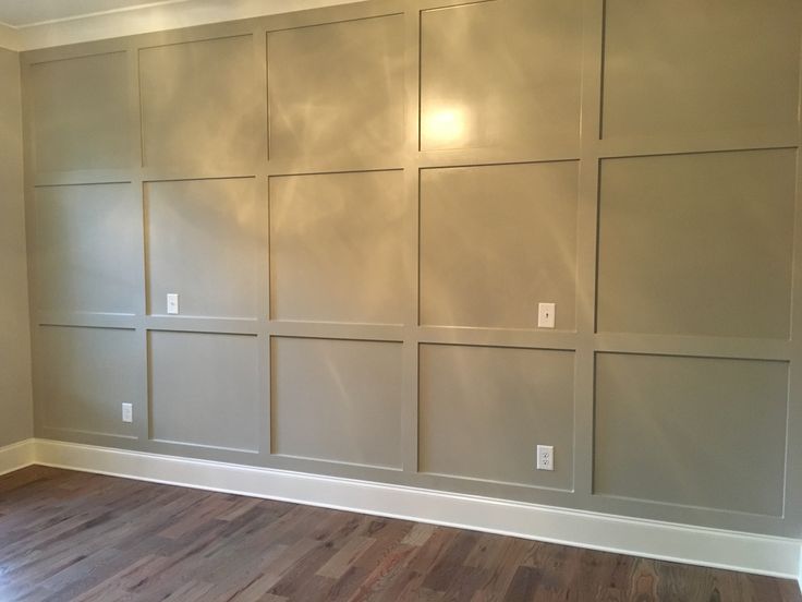 an empty room with wood floors and paneled in panels on the wall that have been painted white