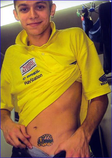 a man with tattoos on his stomach wearing a yellow shirt