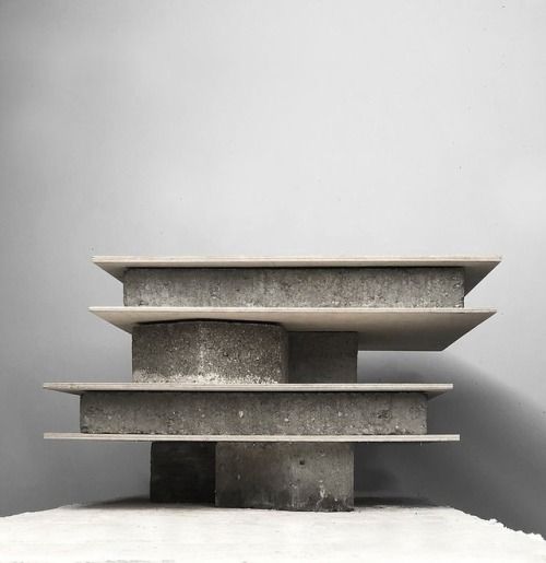 three concrete shelves stacked on top of each other in front of a gray wall and floor