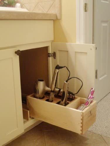 an open drawer with utensils in it on the floor next to a sink