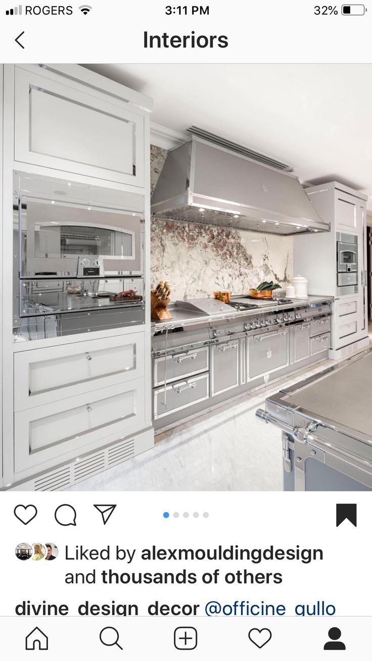 a large kitchen with stainless steel appliances and marble counter tops, along with white cabinets