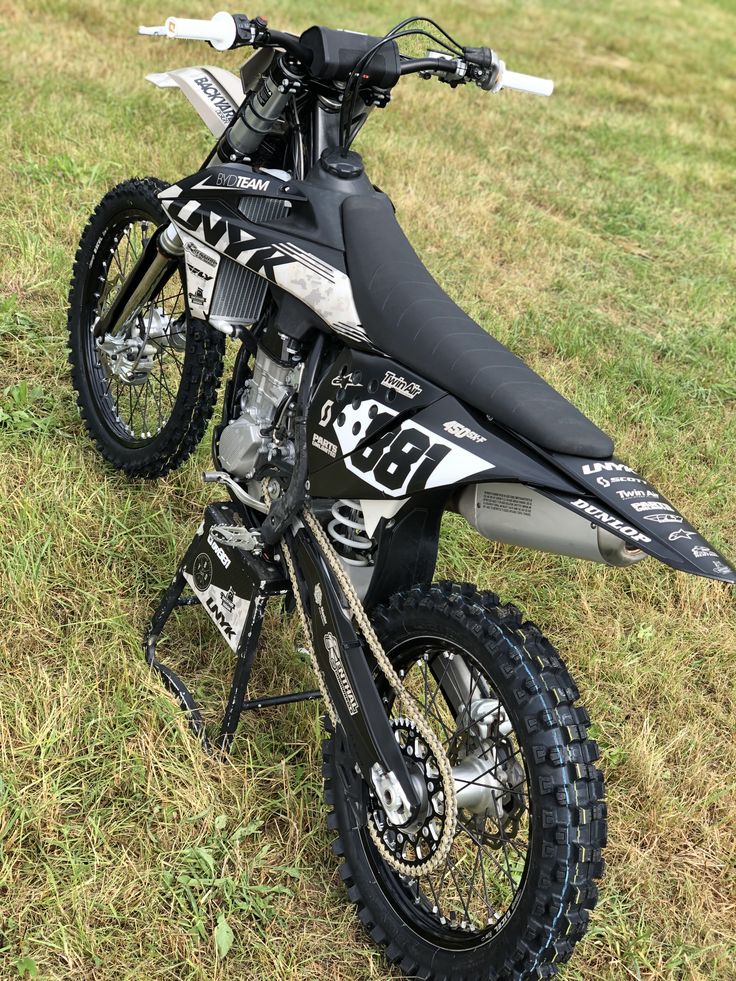 a dirt bike parked on top of a lush green field