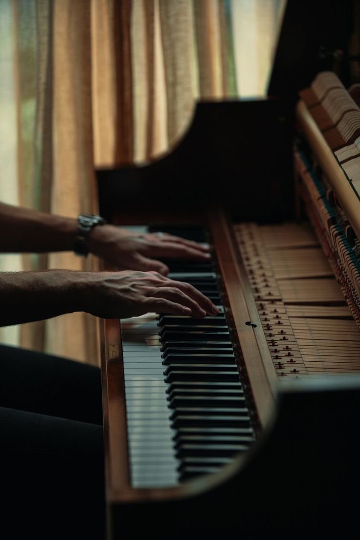 two hands are playing the piano together