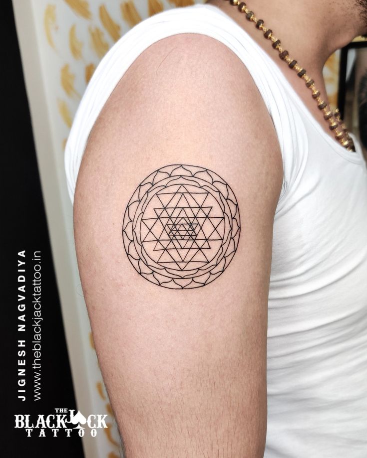 a man with a tattoo on his arm has a flower of life in the center