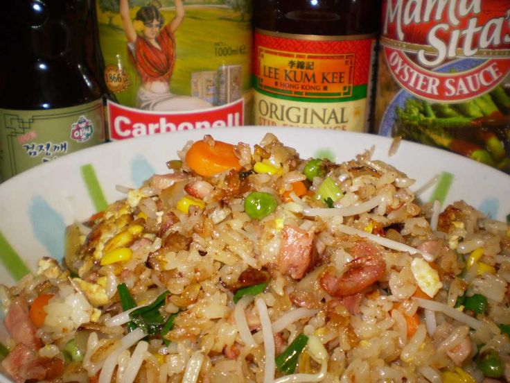 a bowl filled with rice and vegetables next to two bottles