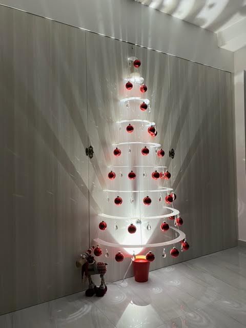 a white christmas tree with red ornaments on it