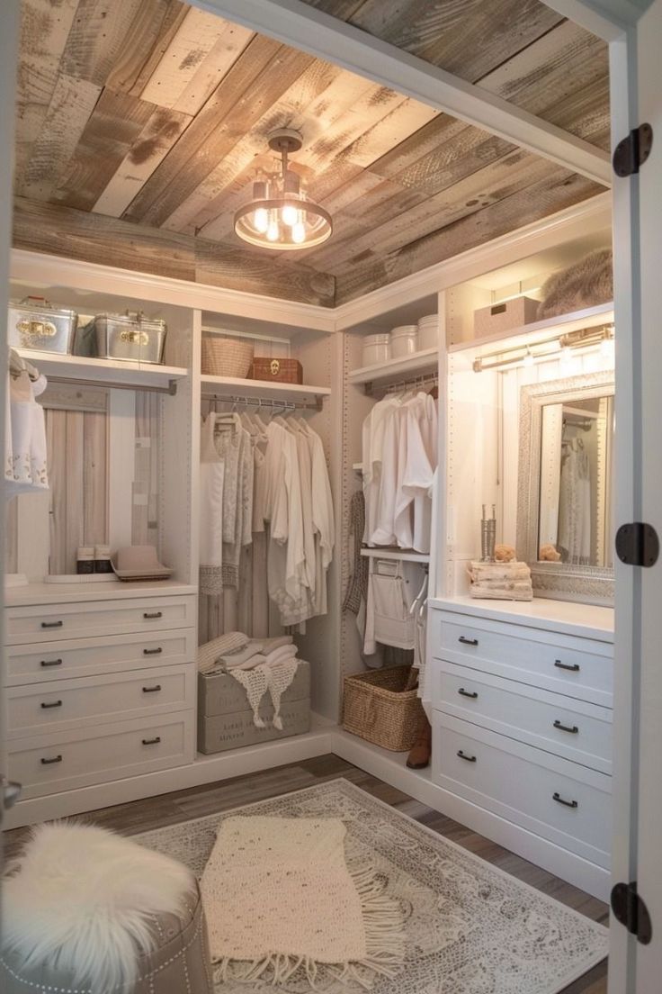 a walk in closet with white cabinets and drawers