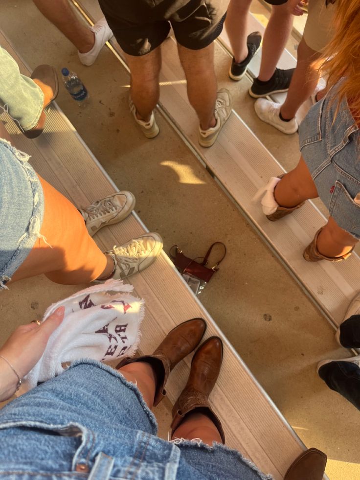 several people standing in front of a mirror with their feet on the ground and one person's reflection