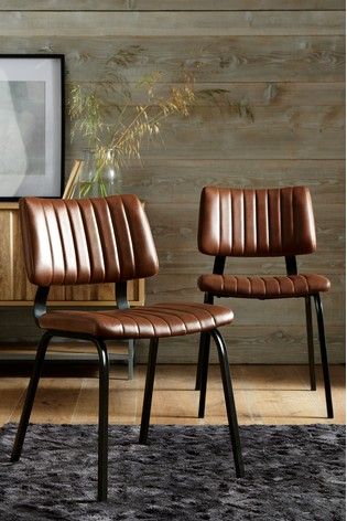 two brown leather chairs sitting next to each other