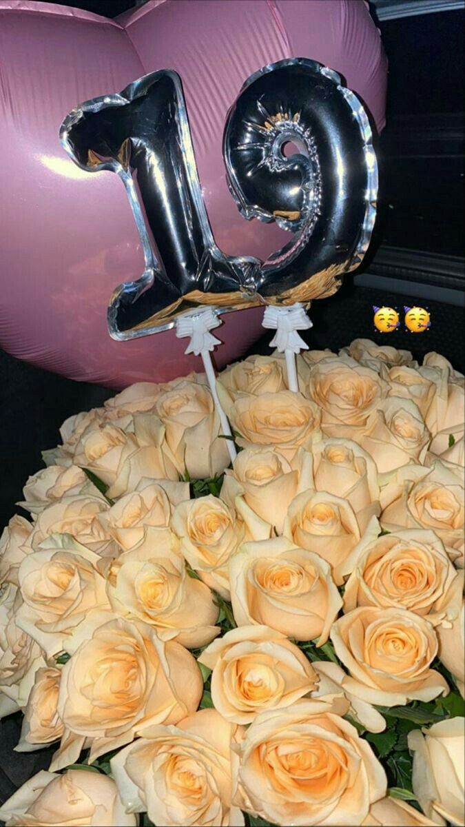 a bouquet of white roses and balloons with the number 19 on them in front of a pink balloon