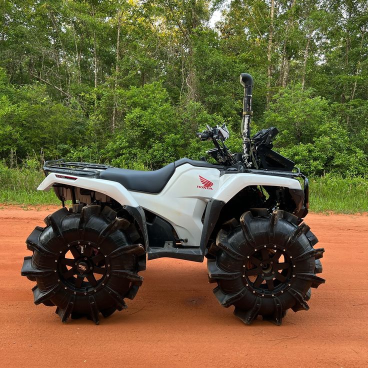 a white four wheeler parked on top of a dirt field