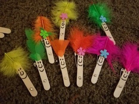 five toothbrushes with different colored feathers and flowers on them sitting on the floor